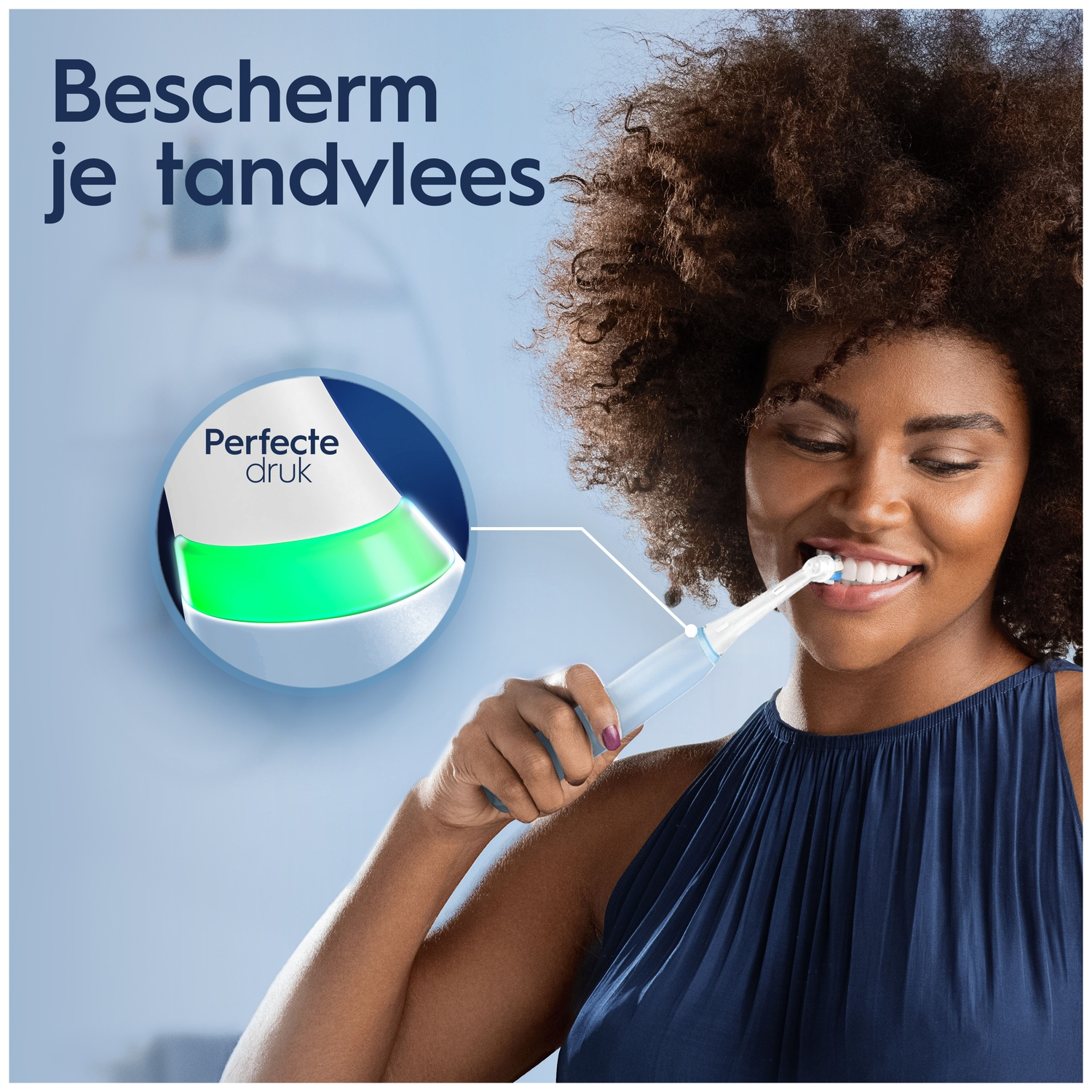 A woman brushes her teeth with an electric toothbrush showing a green light.
