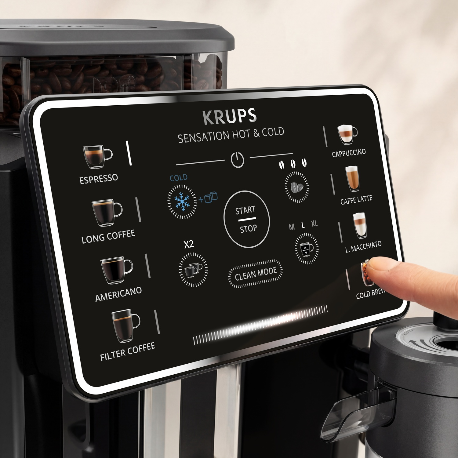 Un doigt touche l'écran tactile d'une machine à café Krups Sensation Hot & Cold.