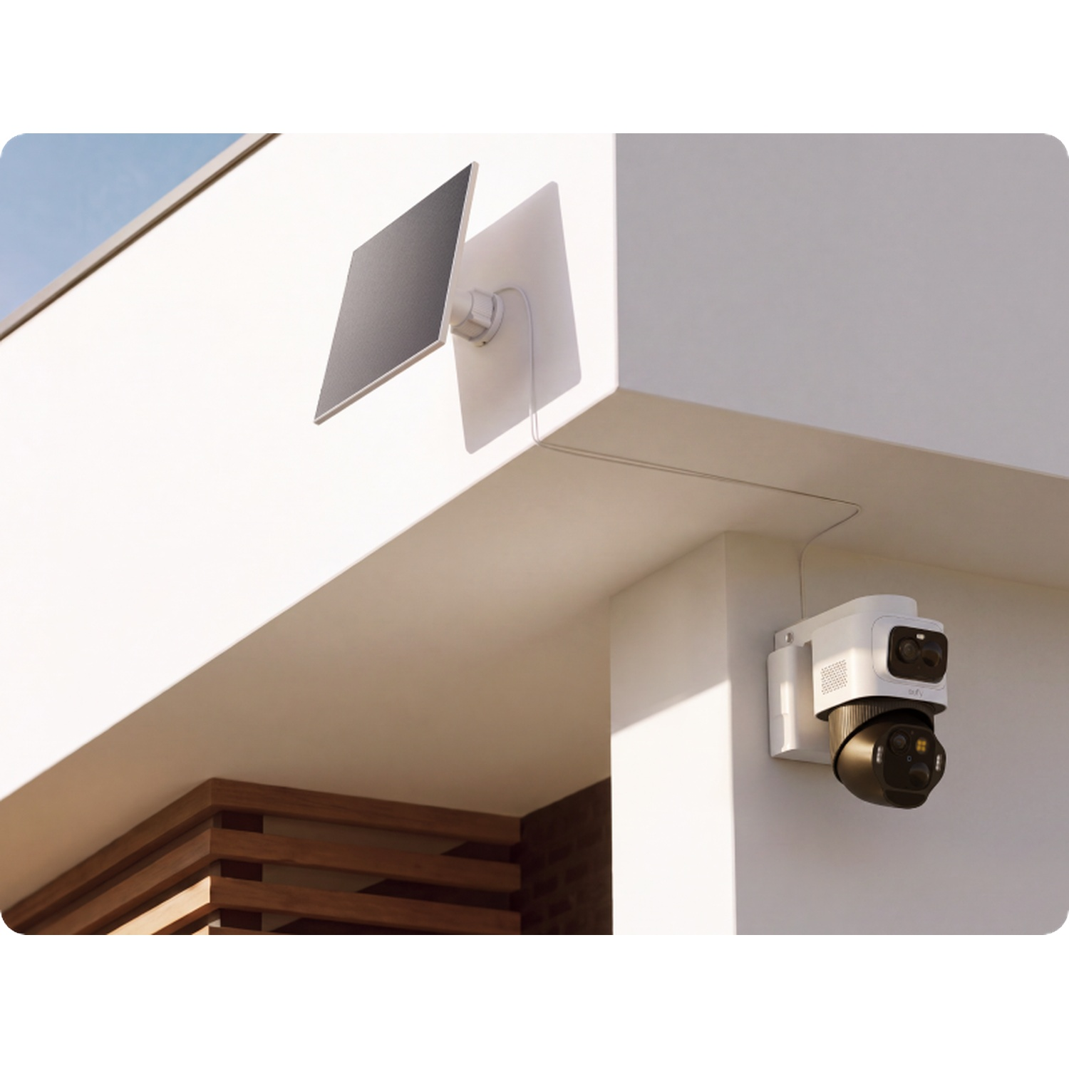 A white security camera with a small solar panel mounted on a modern white wall.