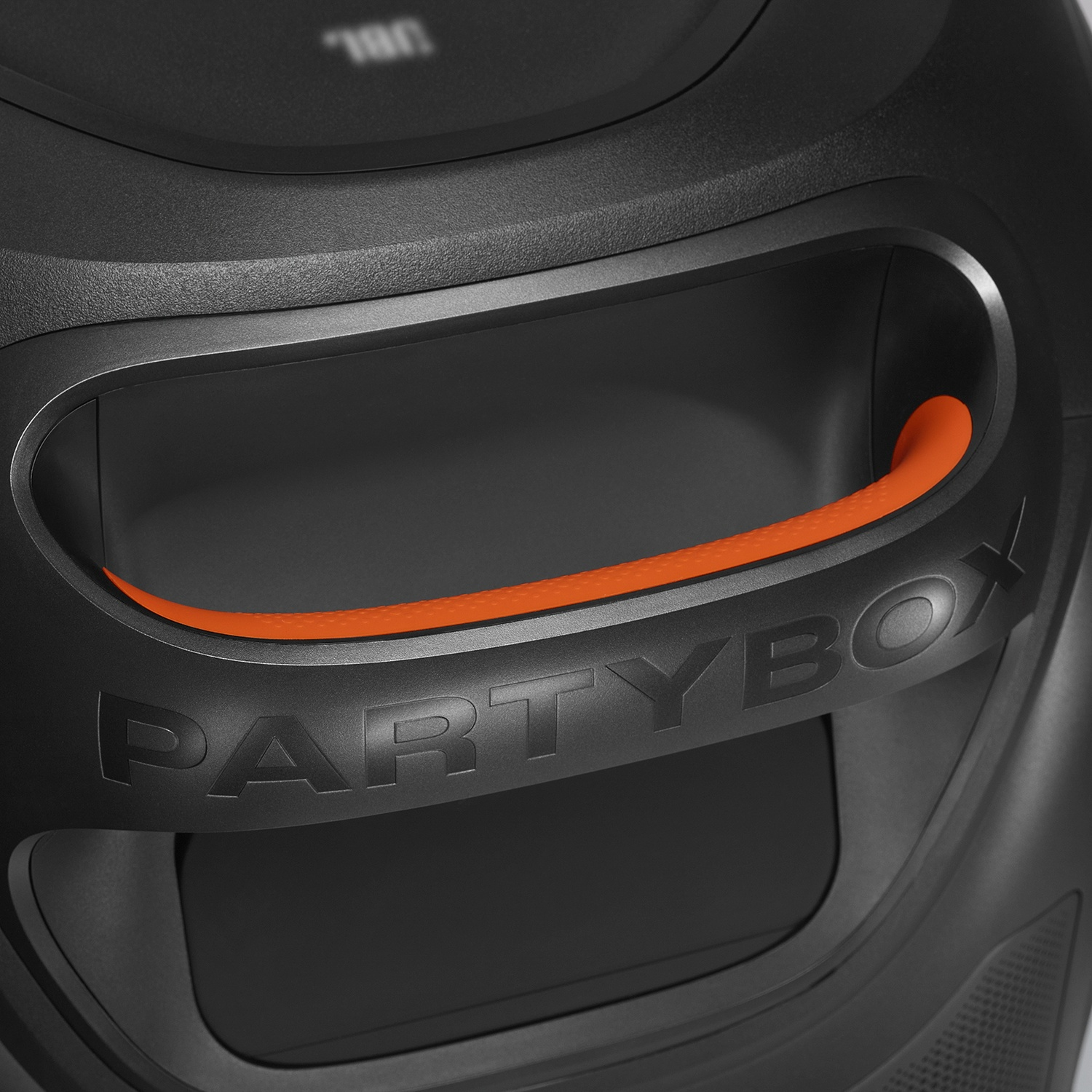 Close-up of a black JBL Partybox speaker featuring a built-in orange handle and embossed logo text.