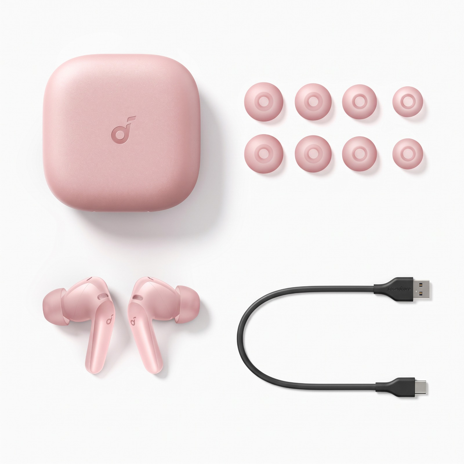 Beyaz zemin üzerinde pembe kablosuz kulaklıklar, şarj kutusu, sekiz yedek uç ve siyah bir USB kablosu.