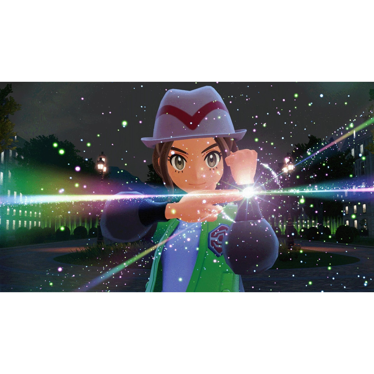 A trainer in a hat and green jacket poses amidst glowing sparkles at night.