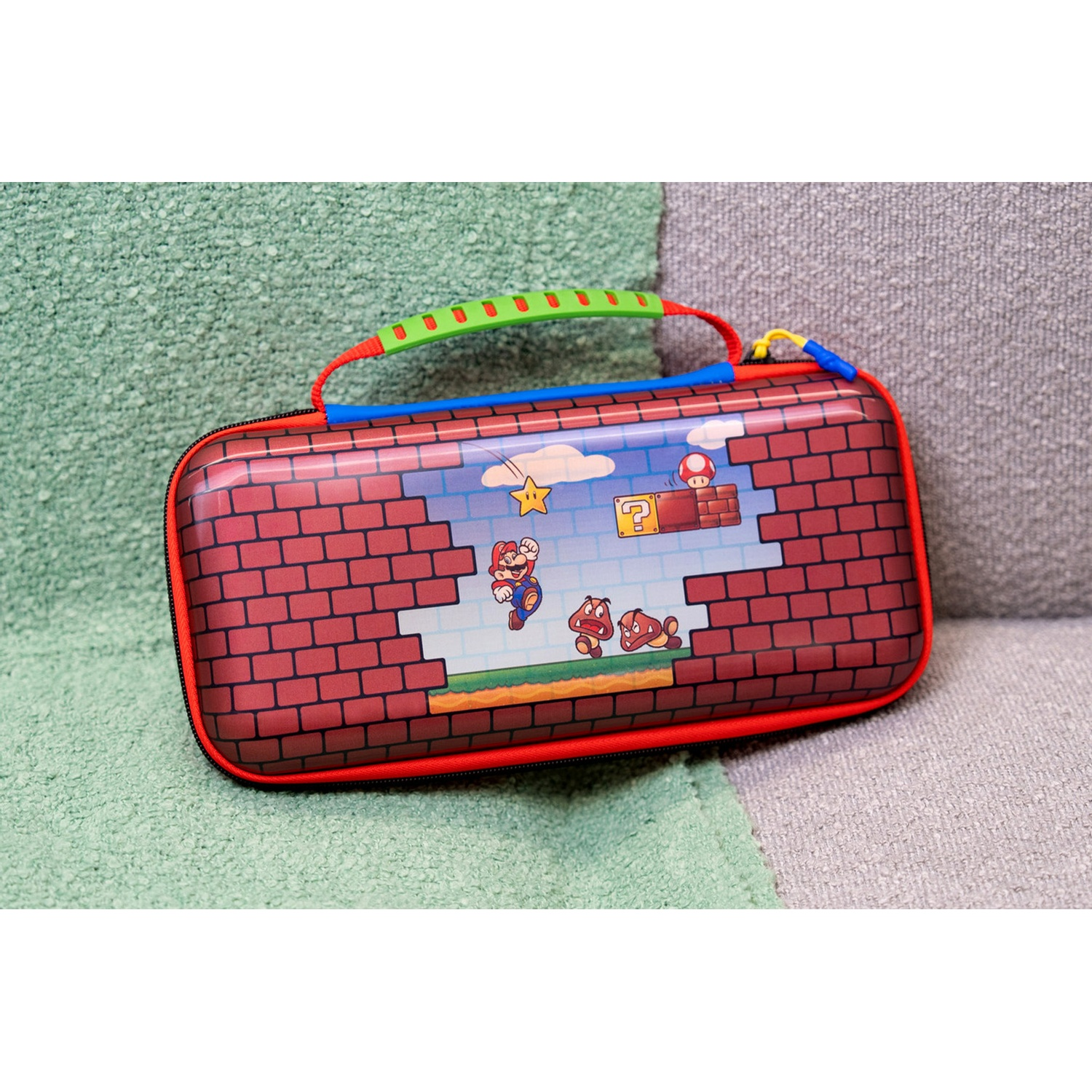 Red Super Mario Nintendo Switch case featuring classic level design, red trim, and a green handle on a textured background.
