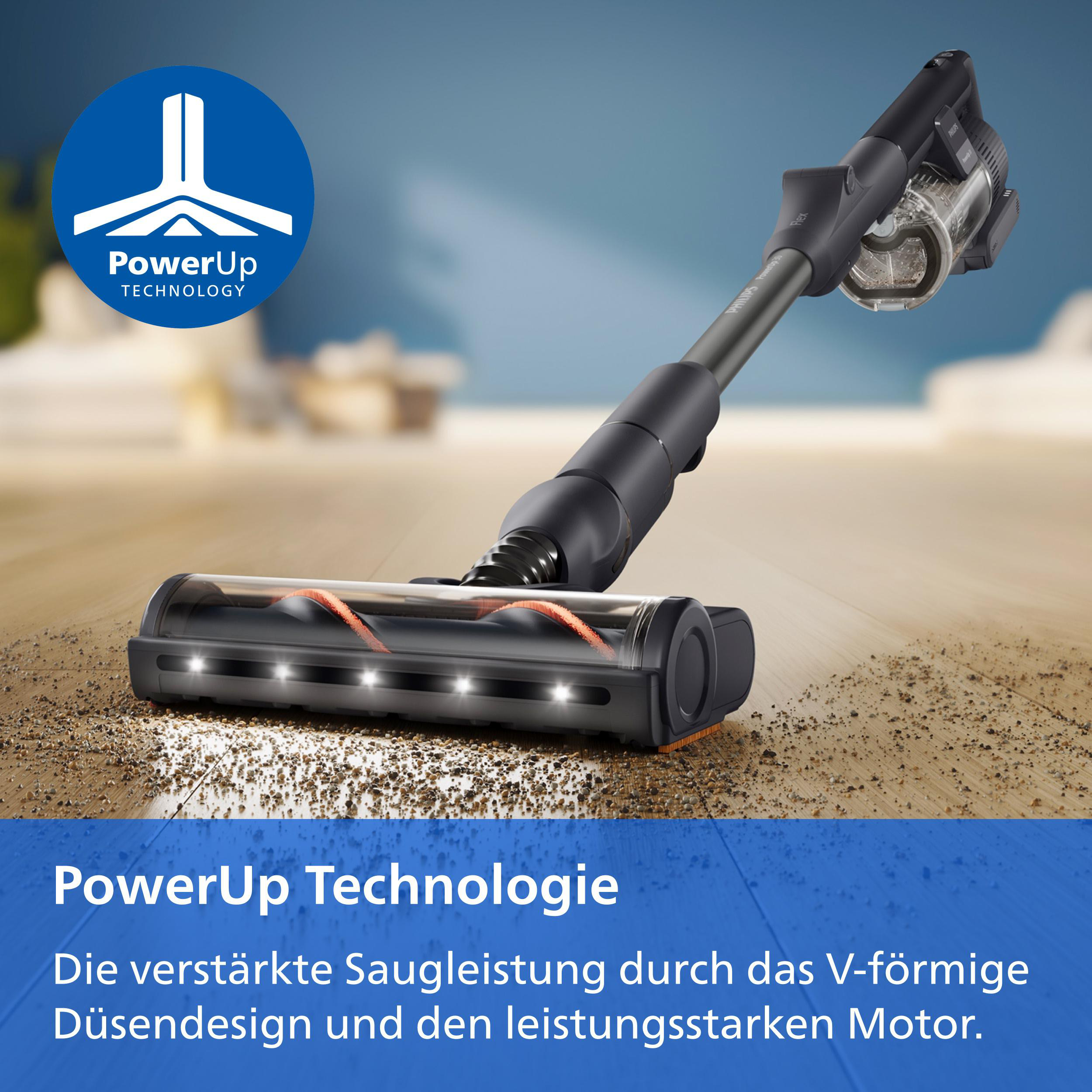 Ein grauer Staubsauger saugt Schmutz von einem Holzfussboden.