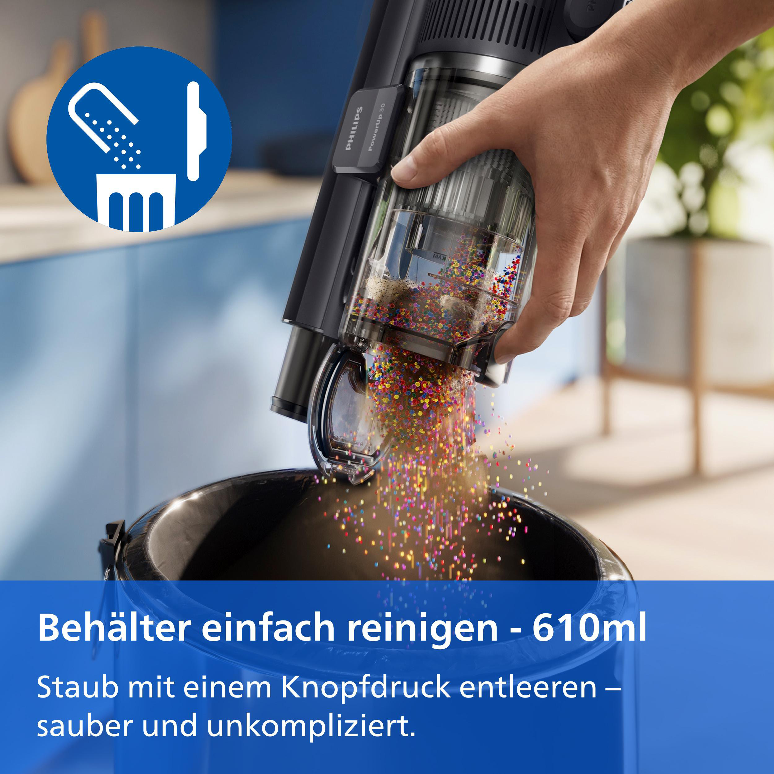Hand leert den Staubsaugerbehälter mit bunten Kügelchen in einen Eimer.