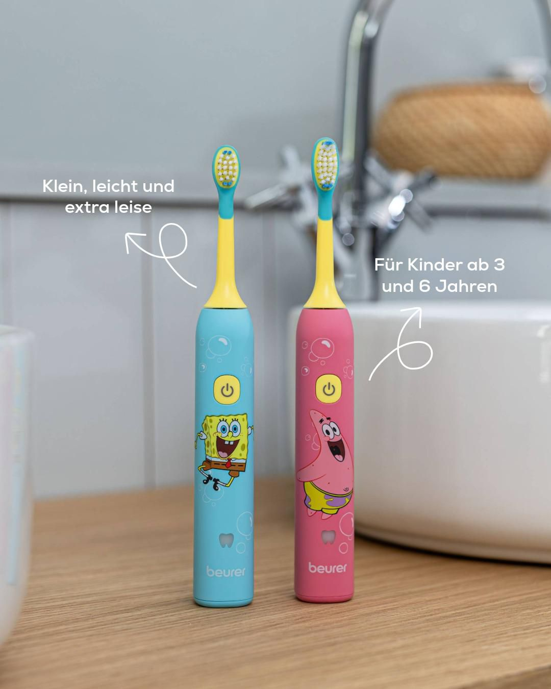 Zwei bunte elektrische Kinderzahnbürsten mit SpongeBob und Patrick im Badezimmer vor Waschbecken.