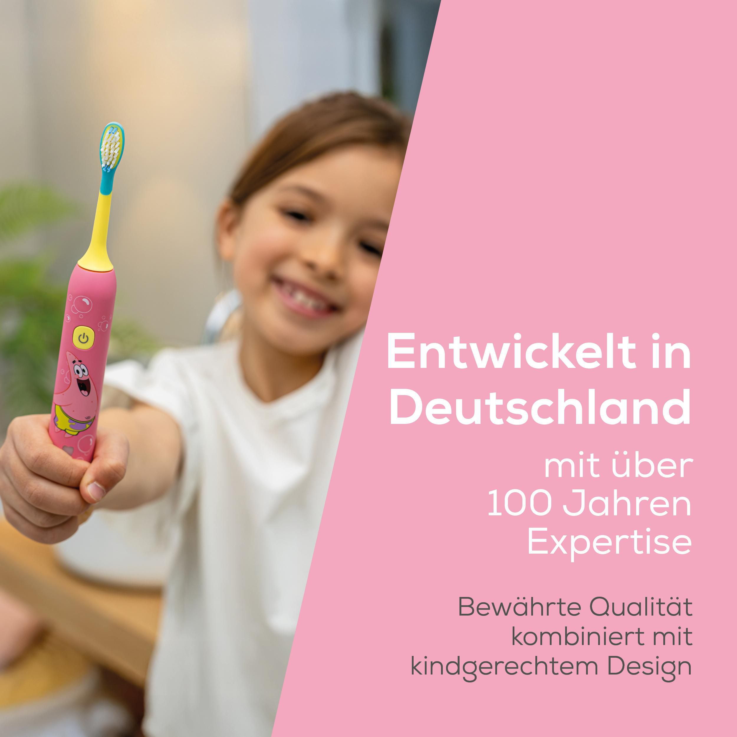 Ein smiling Mädchen zeigt stolz eine pinke Kinderzahnbürste mit Cartoon-Figur.