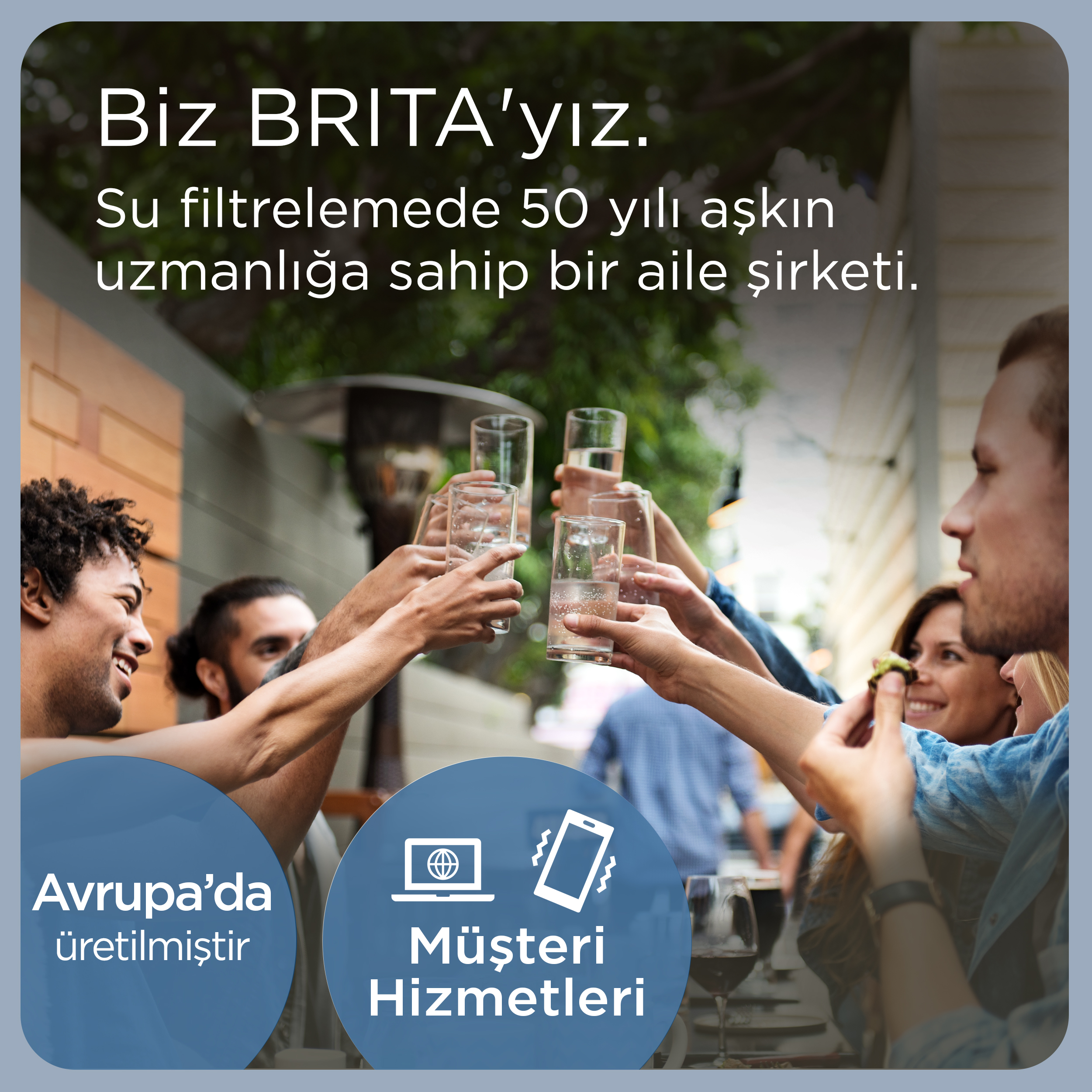 Açık havada su filtreleme hakkında yazılar eşliğinde bardaklarla kadeh tokuşturan arkadaşlar.