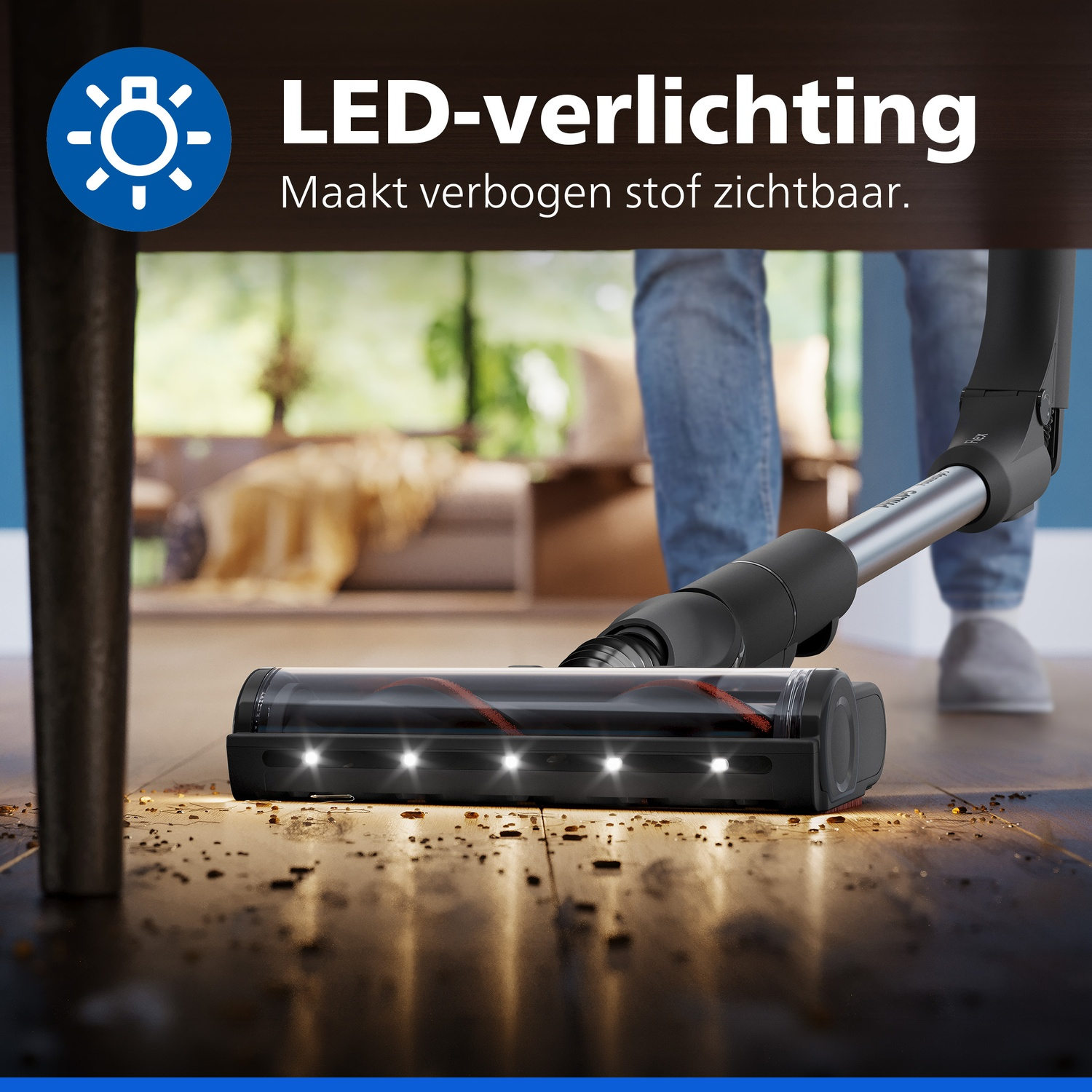 A vacuum cleaner with LED lights illuminates dirt on the floor under a table.