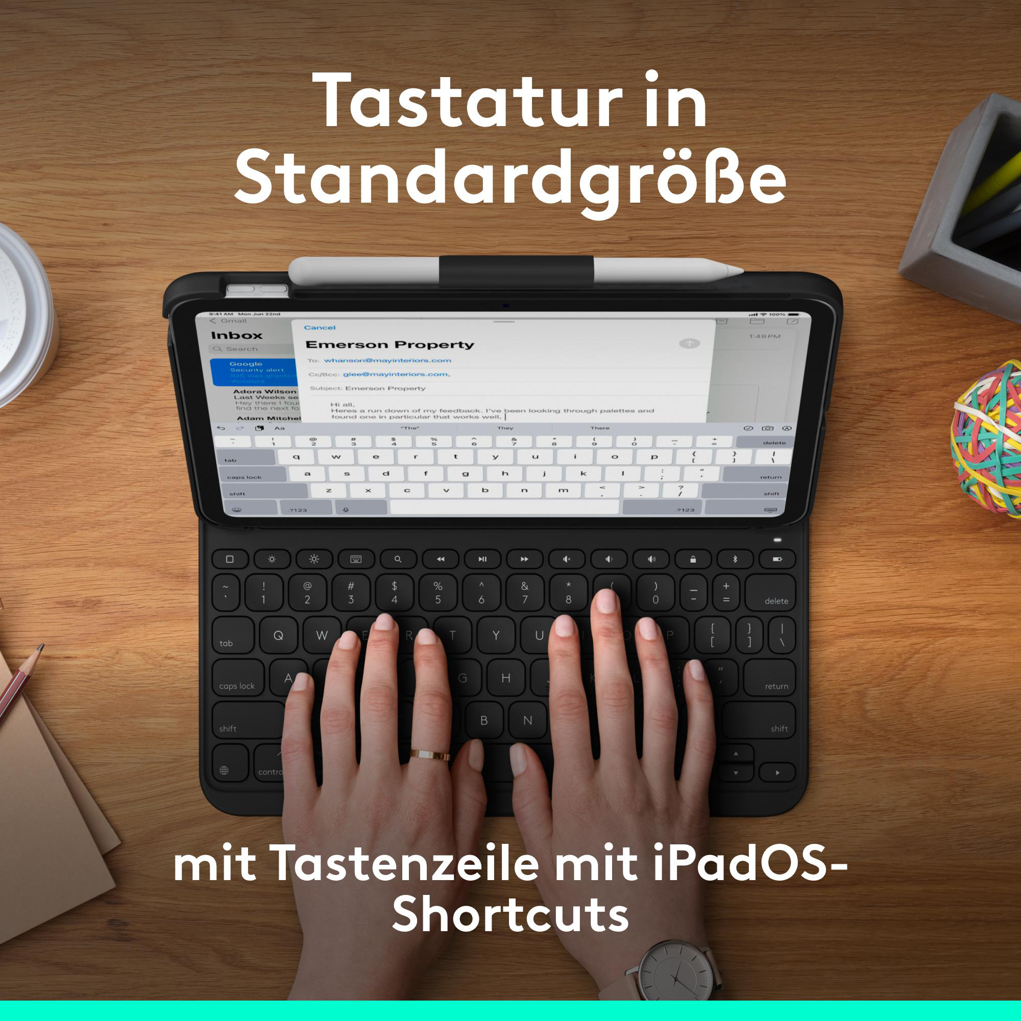Hände tippen auf einer iPad-Tastatur auf einem Holztisch.