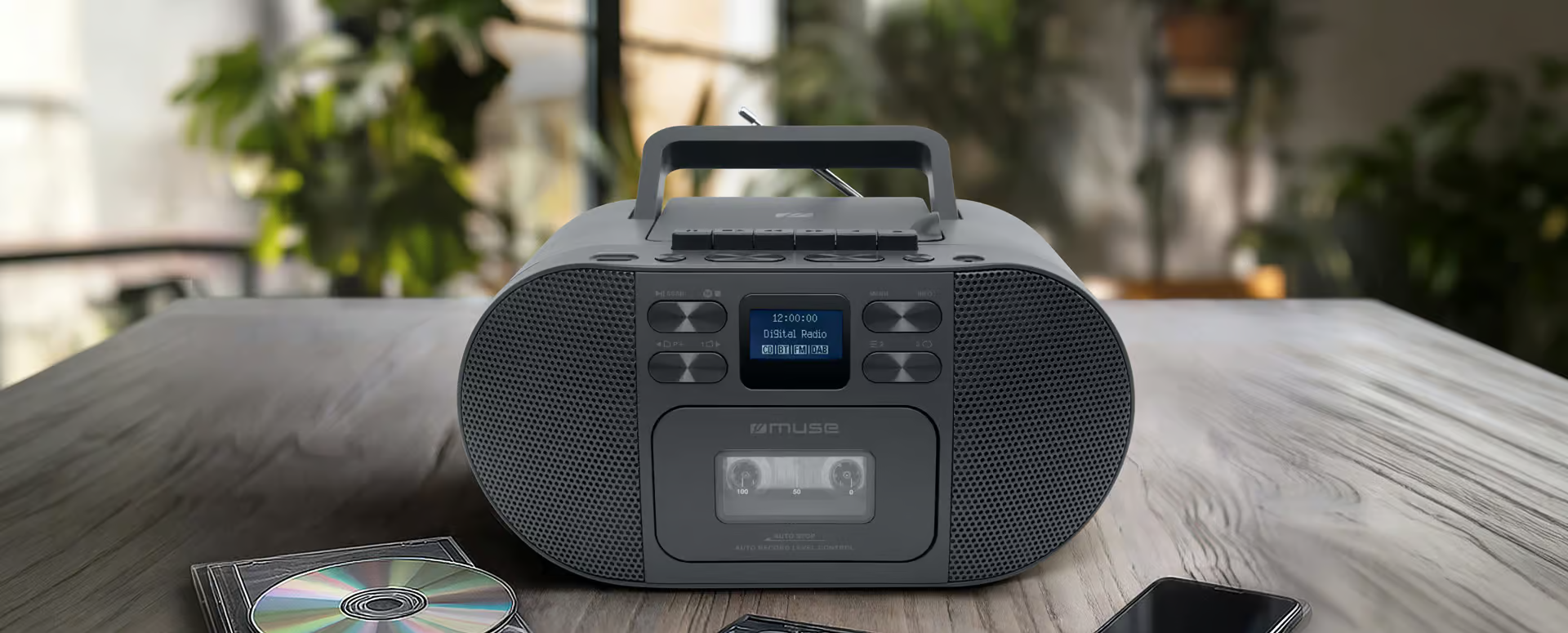Ghetto-blaster cassette gris avec écran numérique sur table en bois, près d'un CD.