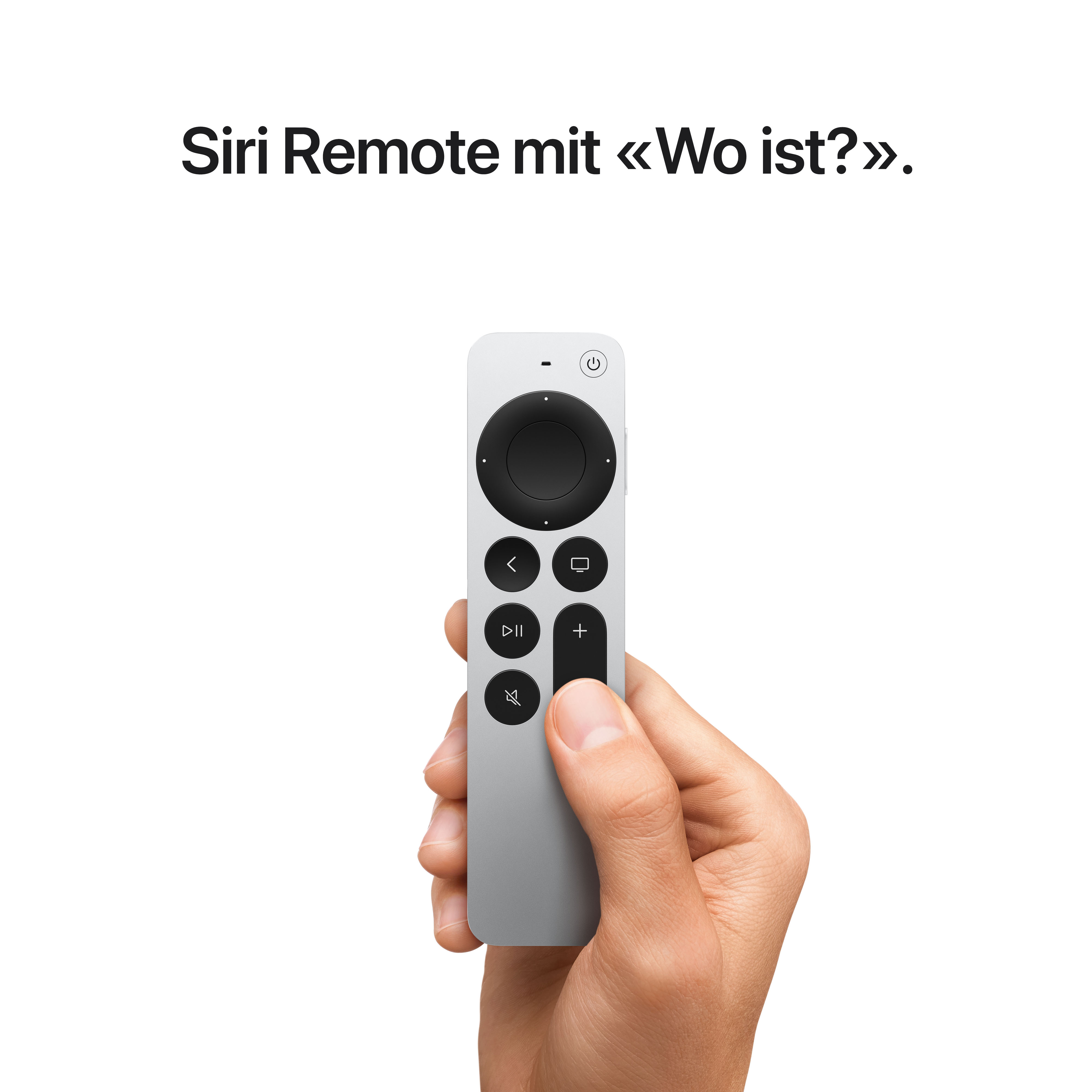 Une main tenant une Siri Remote Apple argentée sur fond blanc.