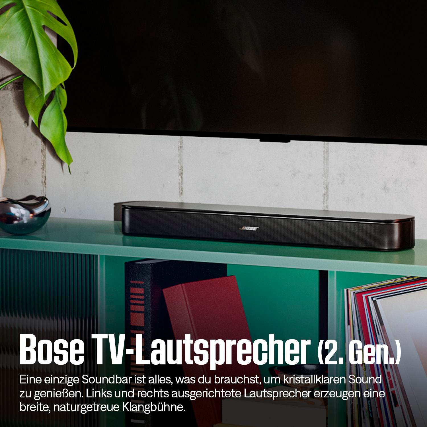 Eine schwarze Bose Soundbar steht auf einem grünen Regal unter einem Fernseher.