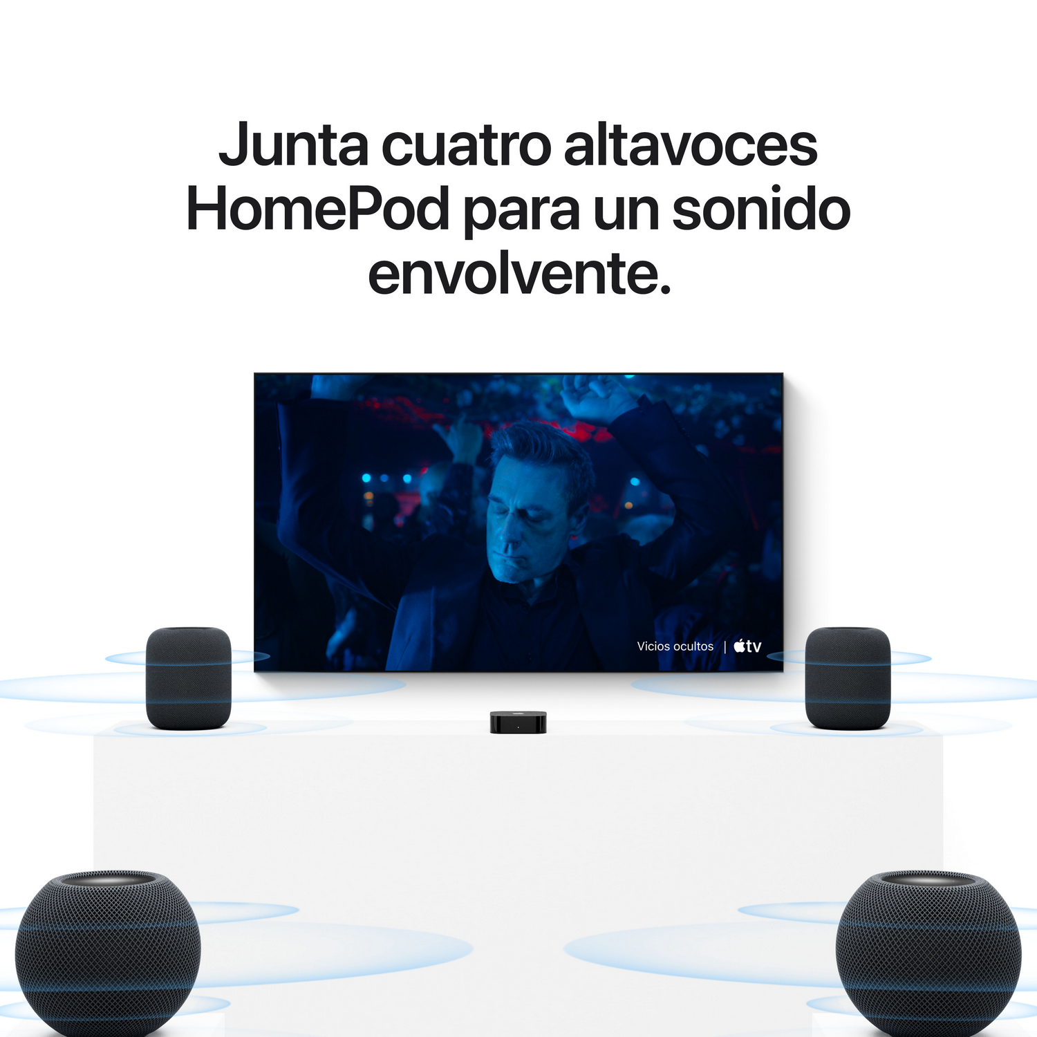 Cuatro altavoces HomePod rodean un televisor en una superficie blanca, mostrando ondas de sonido.