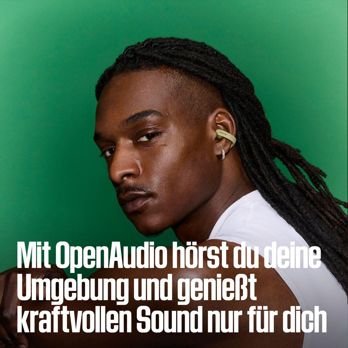 Ein Mann mit Dreadlocks und ohrumschließenden Kopfhörern vor grünem Hintergrund mit deutschem Werbetext.