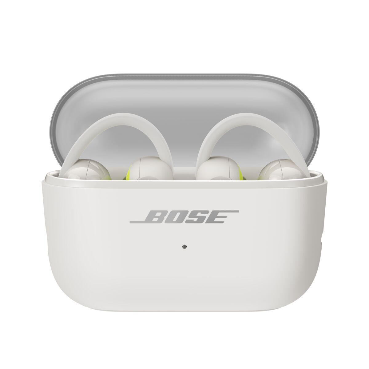 Weiße Bose-Ohrhörer in einer offenen Ladebox mit Logo und LED-Leuchte auf grauem Hintergrund.
