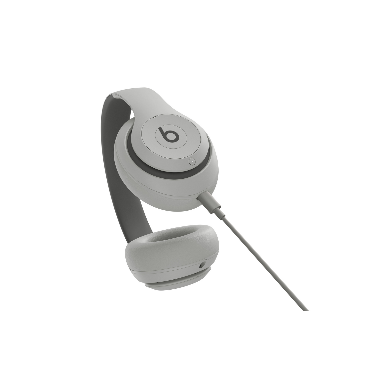 Auriculares supraaurales Beats grises con un cable de audio conectado sobre fondo blanco.