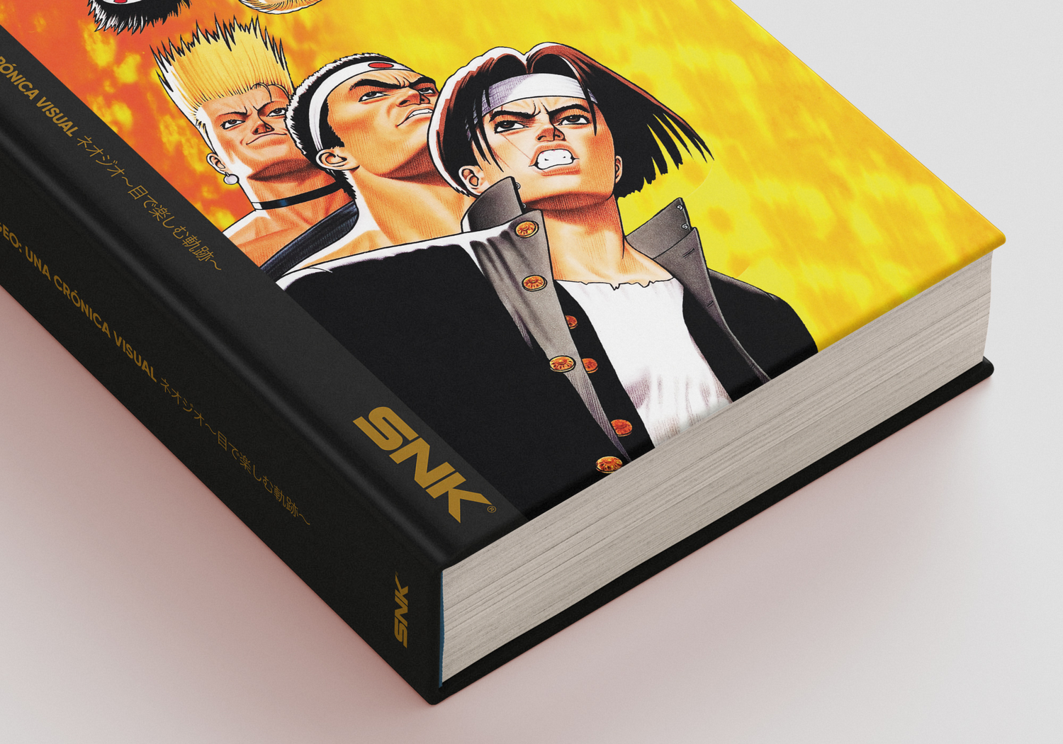 Un libro cerrado con cubierta amarilla y el logotipo de SNK, con personajes de anime en la portada.