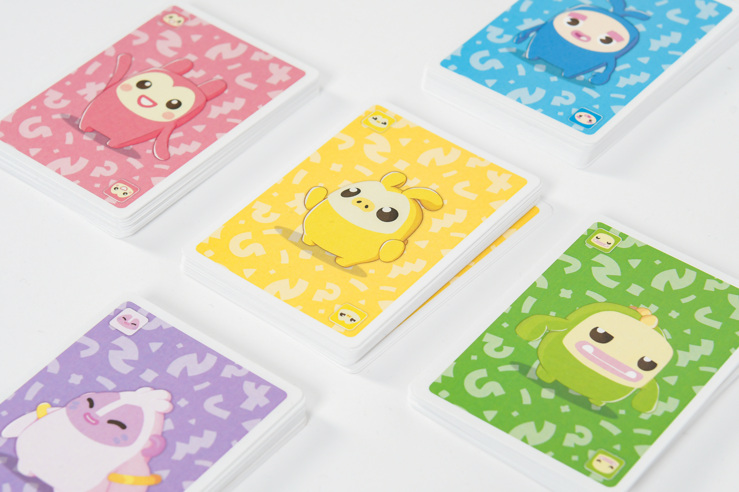Cinco coloridas barajas de cartas con simpáticos monstruos de dibujos animados sobre fondo blanco.