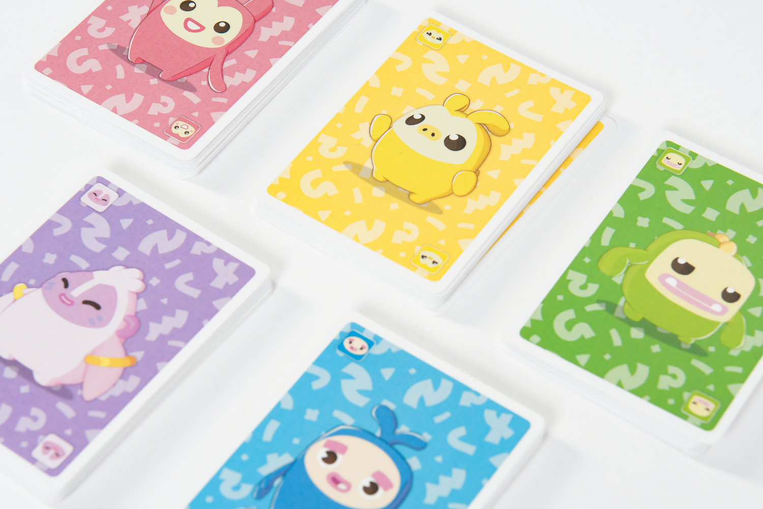 Cinco barajas de cartas de colores con lindos personajes de dibujos animados sobre un fondo blanco.
