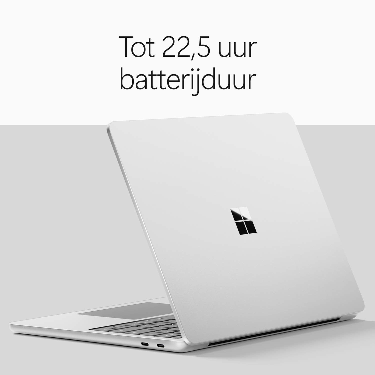 Een zilveren laptop tegen een grijze achtergrond met tekst erboven.
