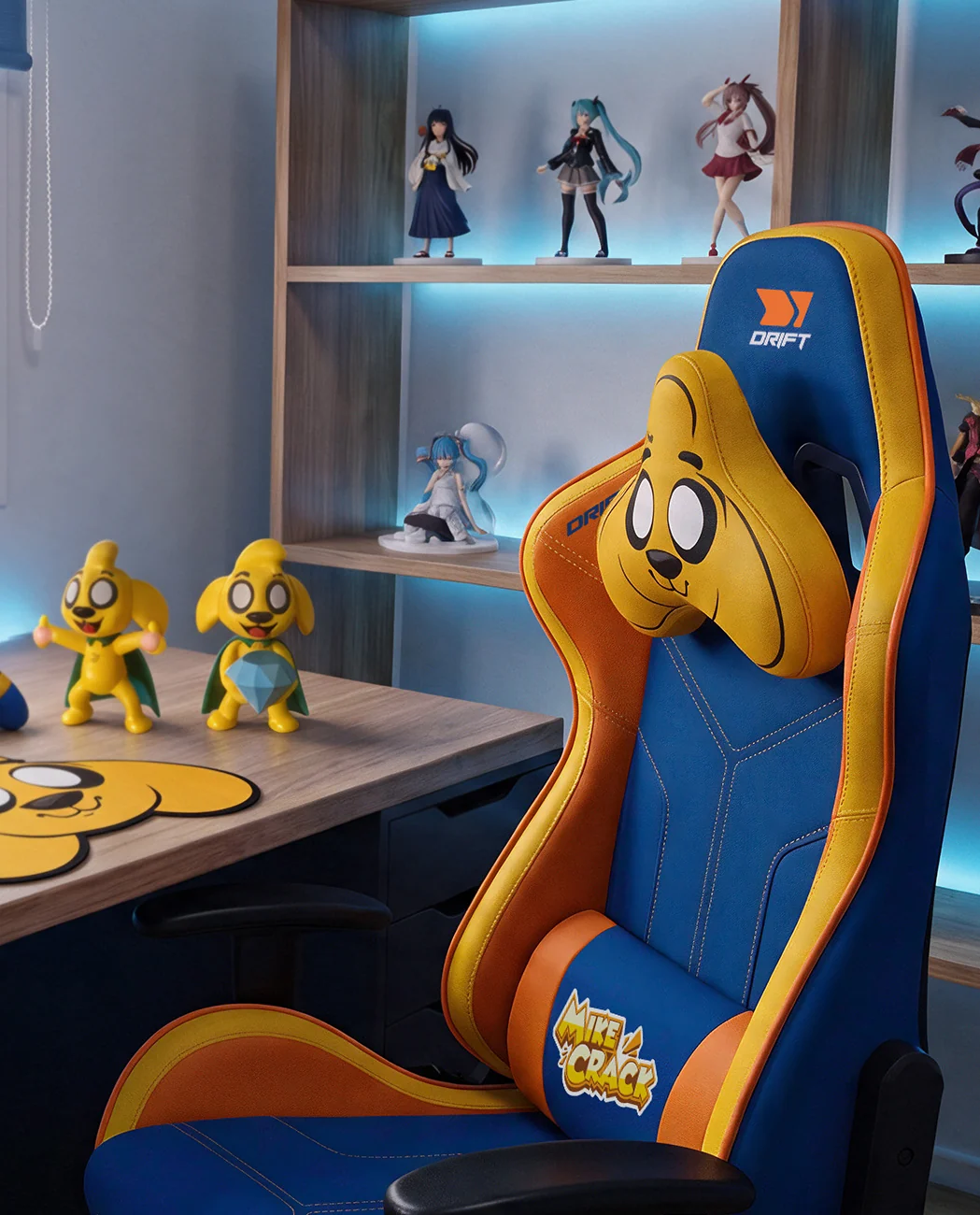 Una silla gamer azul y amarilla con tema de perro en una habitación con escritorio, figuras anime y luz azul.