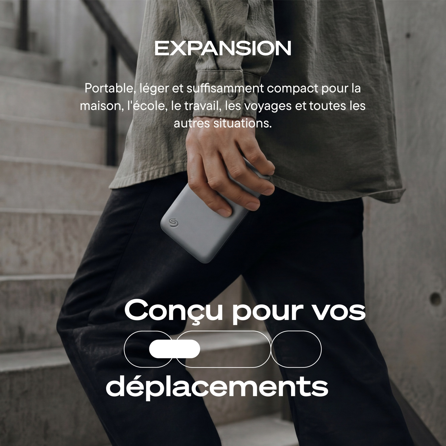 Une personne tient un disque portable gris, avec du texte promotionnel en français.