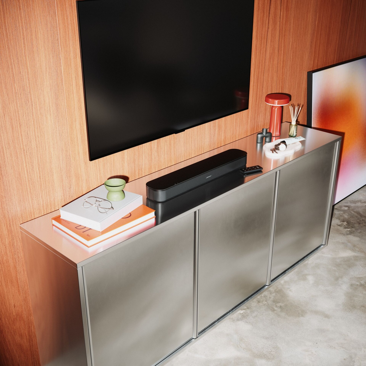 Een zilveren kast met boeken, een soundbar en decoratie voor een houten wand en een tv.