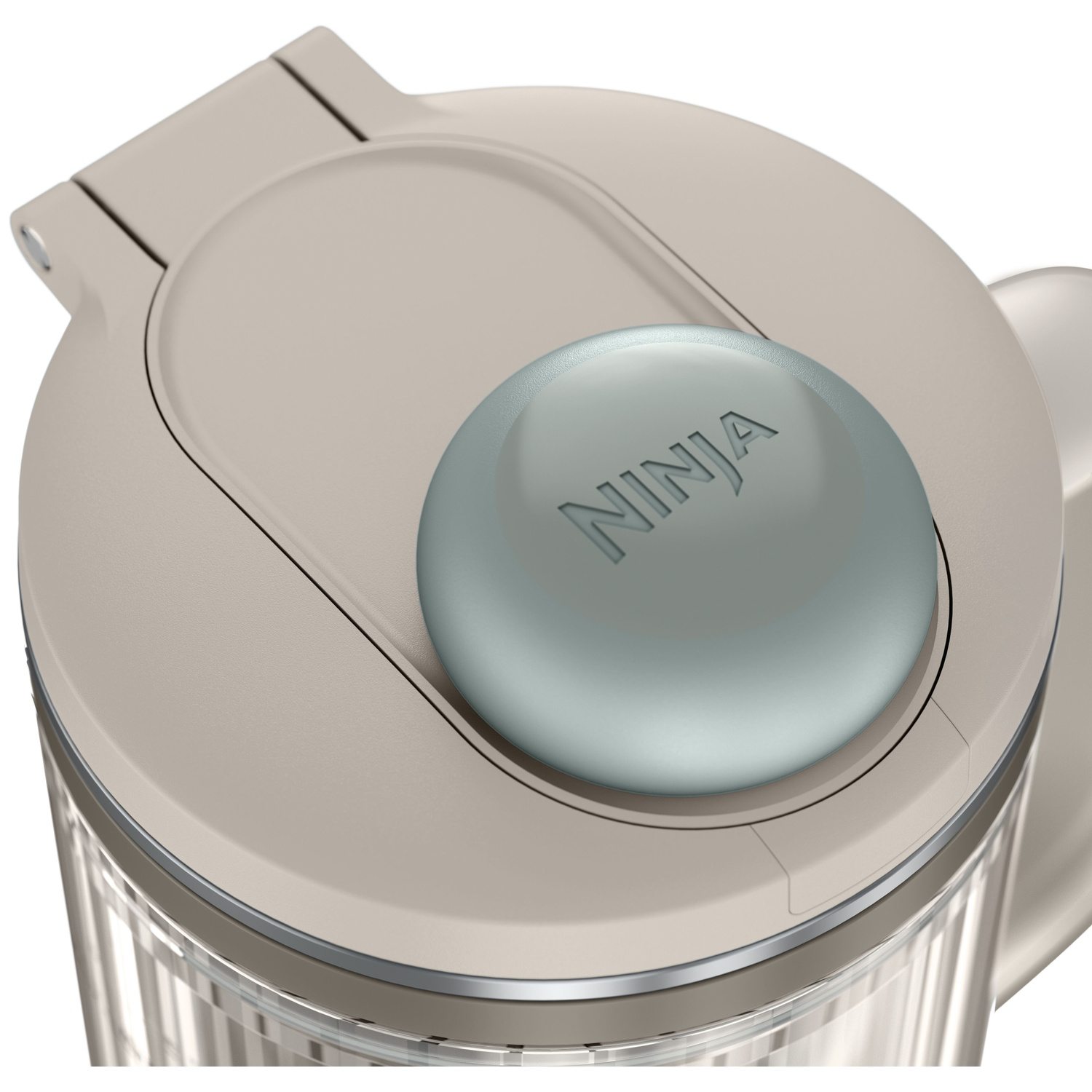 Vue de dessus du couvercle d'un blender Ninja beige avec un bouton gris rond.