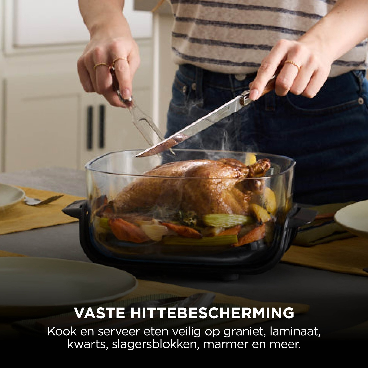 A person is carving a roasted chicken with vegetables in a glass dish.