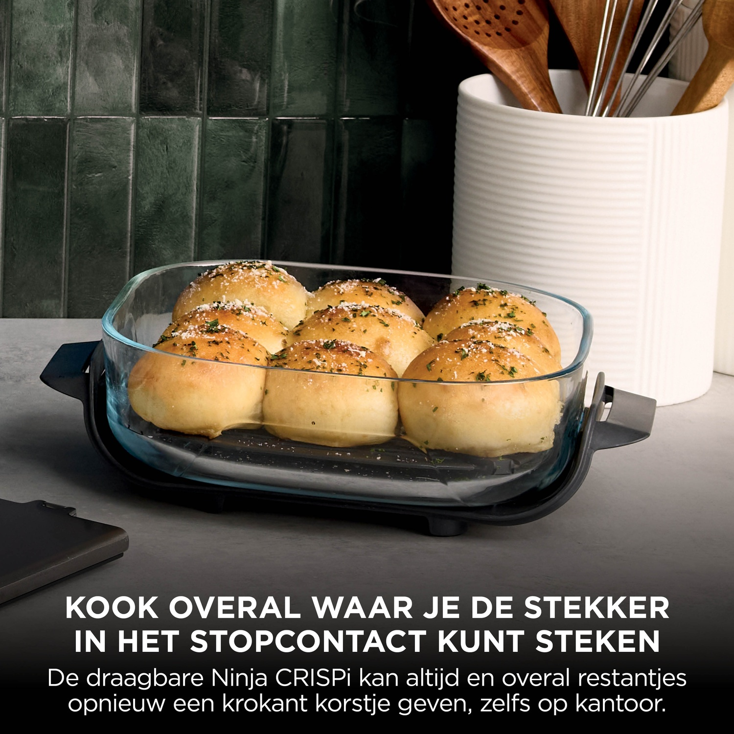 Golden brown rolls with herbs and cheese in a glass baking dish on a kitchen counter.