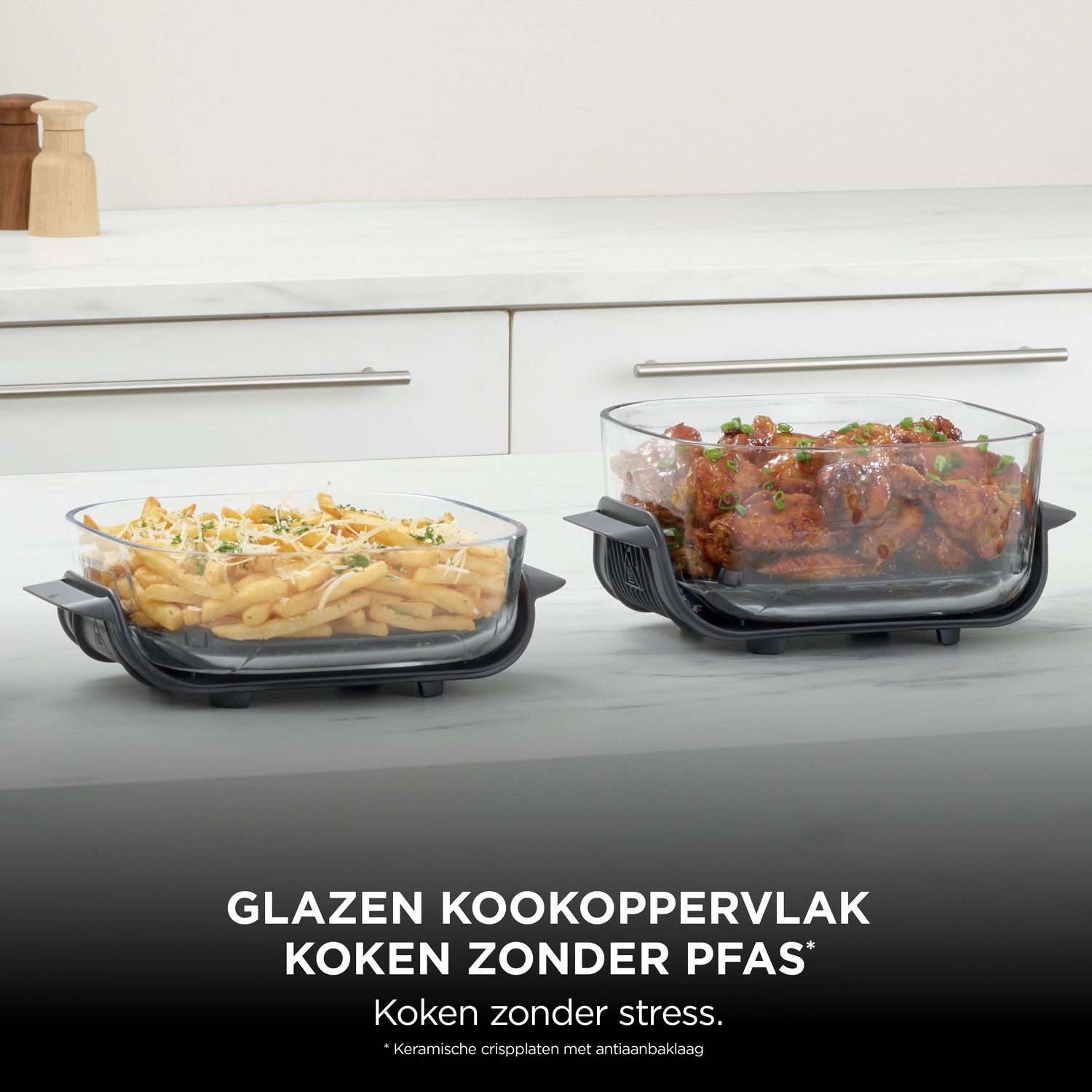 Two glass dishes with fries and chicken on a kitchen counter with text.