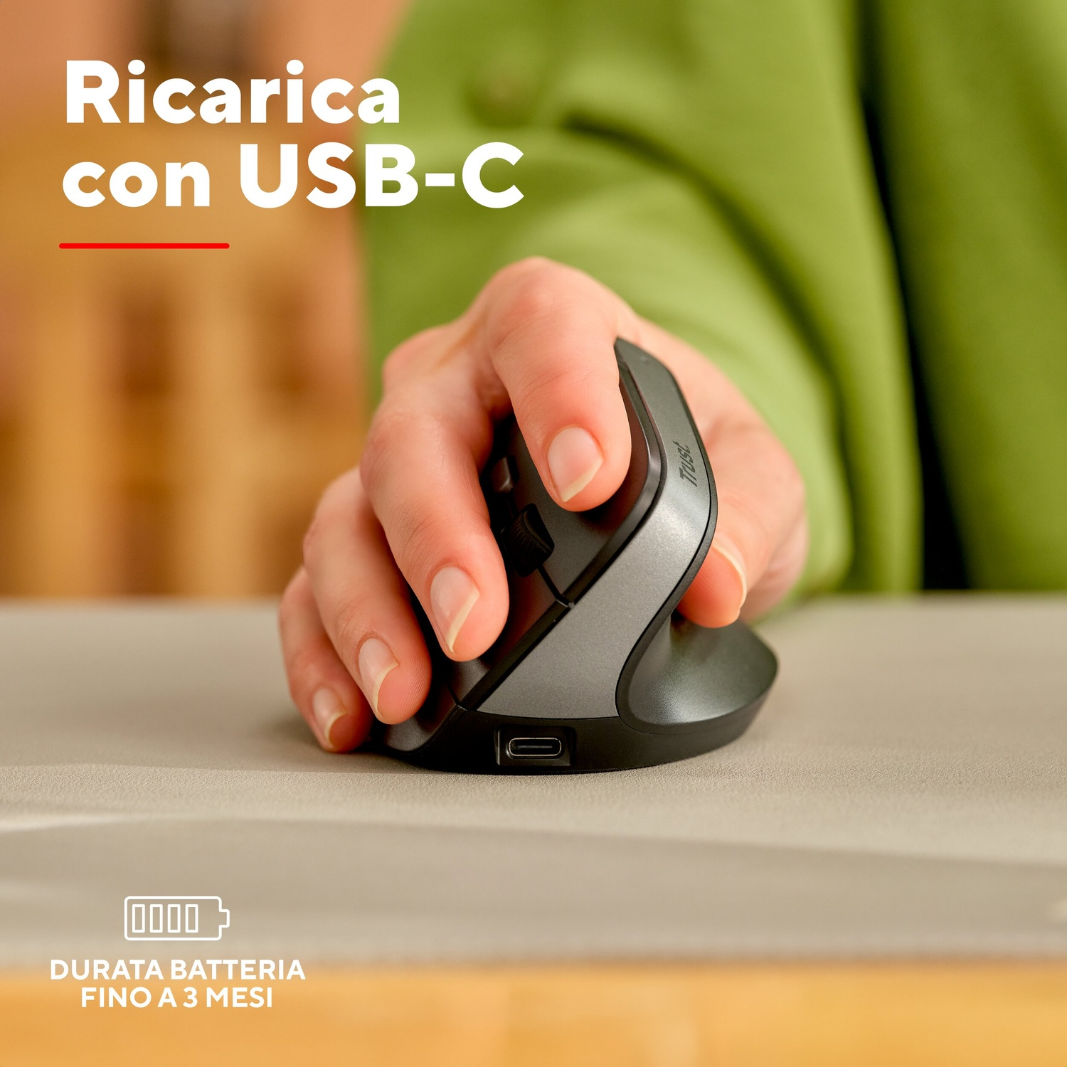 Una mano utilizza un mouse ergonomico verticale con porta USB-C su una scrivania.
