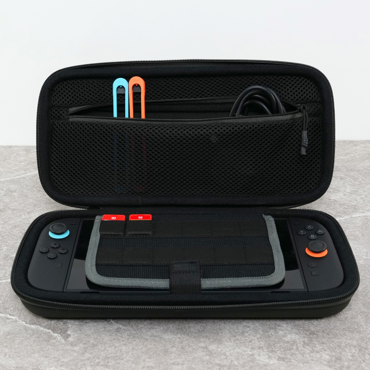 Black carrying case containing a Nintendo Switch console and accessories inside.