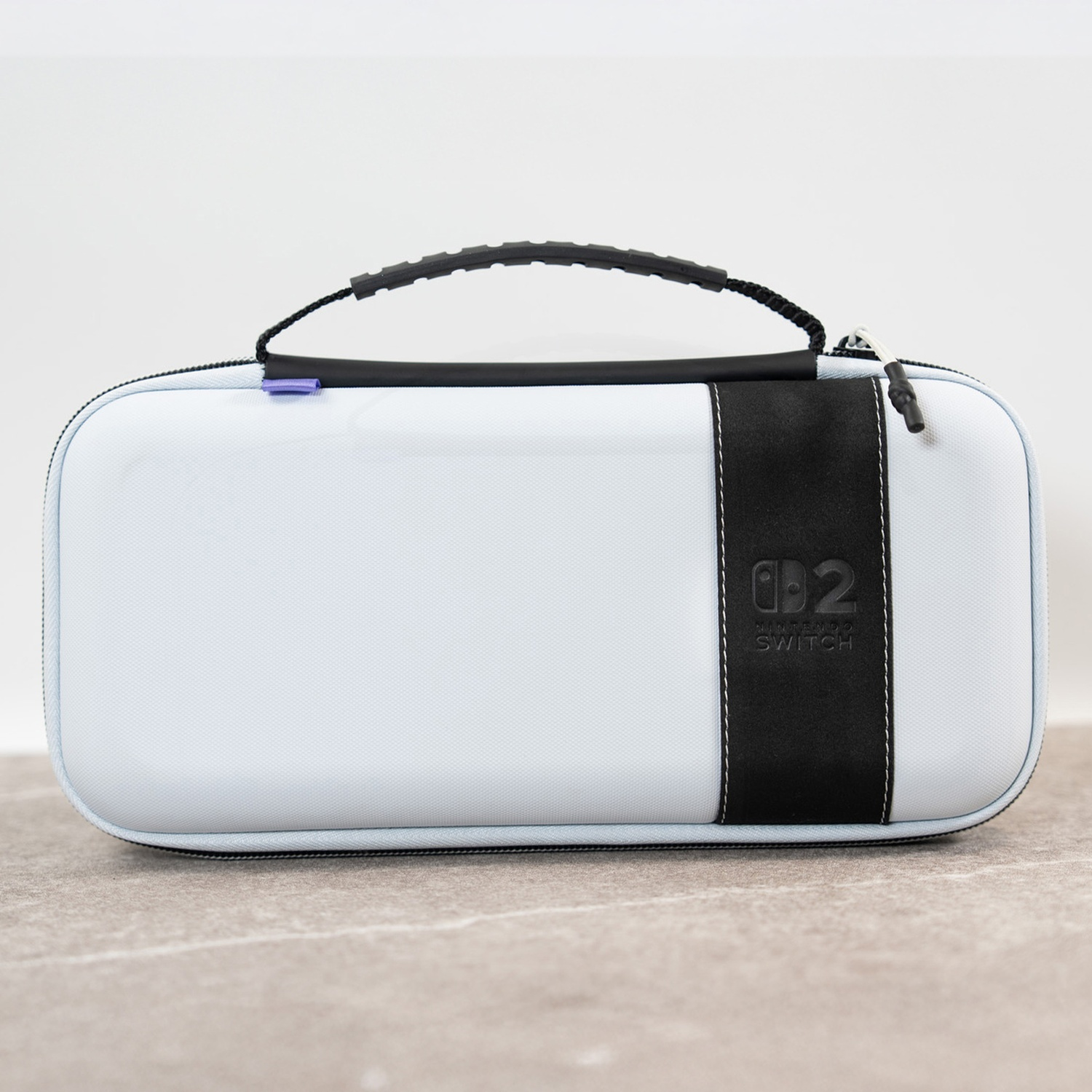 A light blue Nintendo Switch carrying case with a black handle and a vertical black stripe.