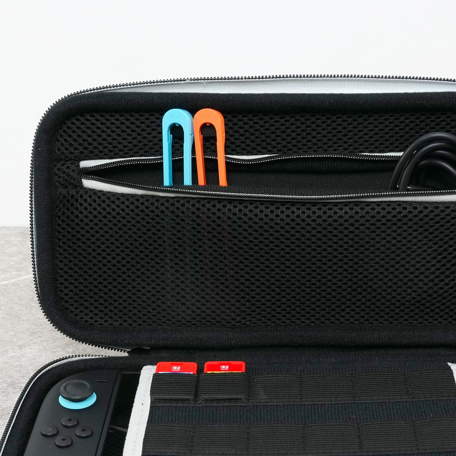 Open black case with blue and orange accessories and a game console.