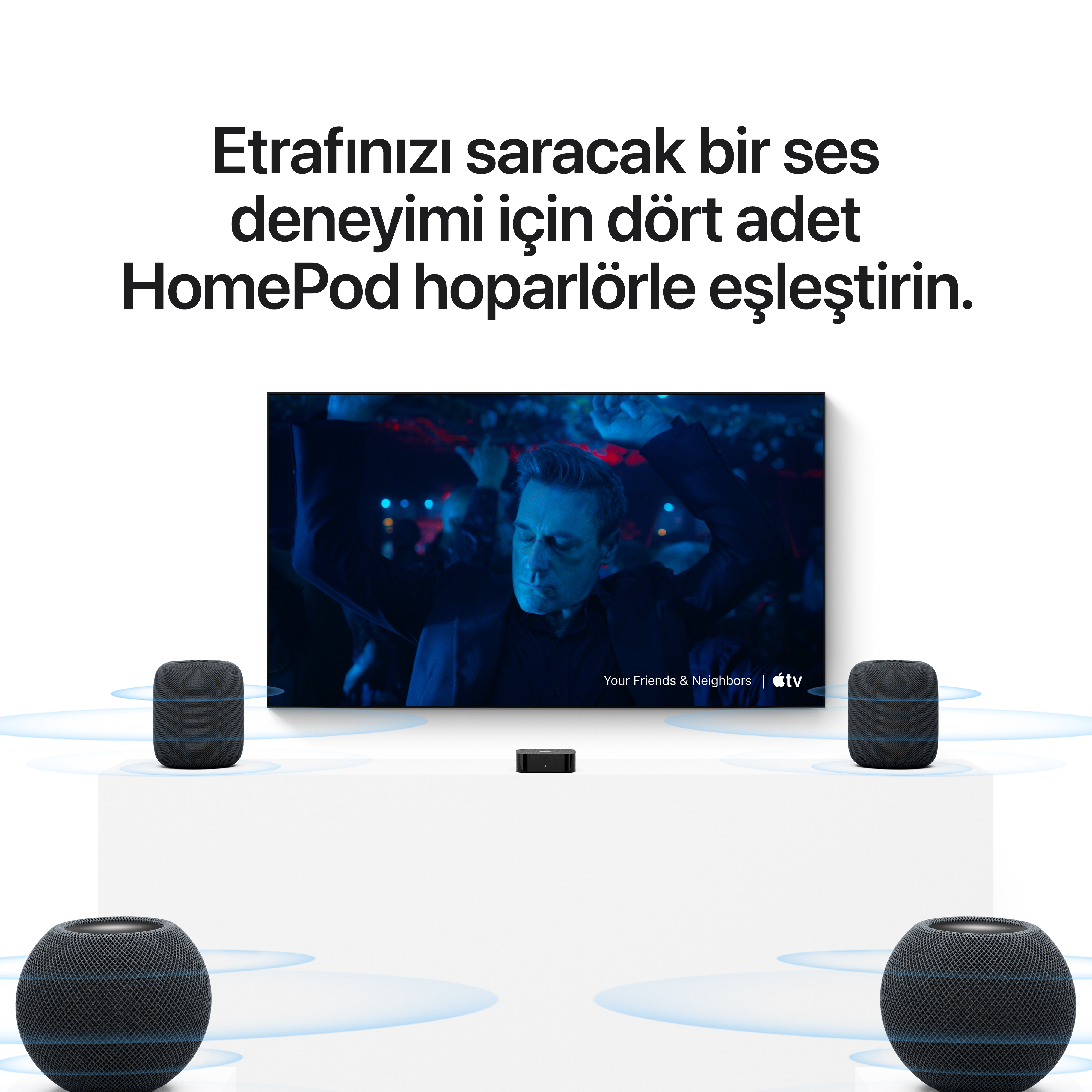 Beyaz stantlar üzerinde mavi ses dalgaları yayan dört HomePod hoparlörlü bir TV ekranı.