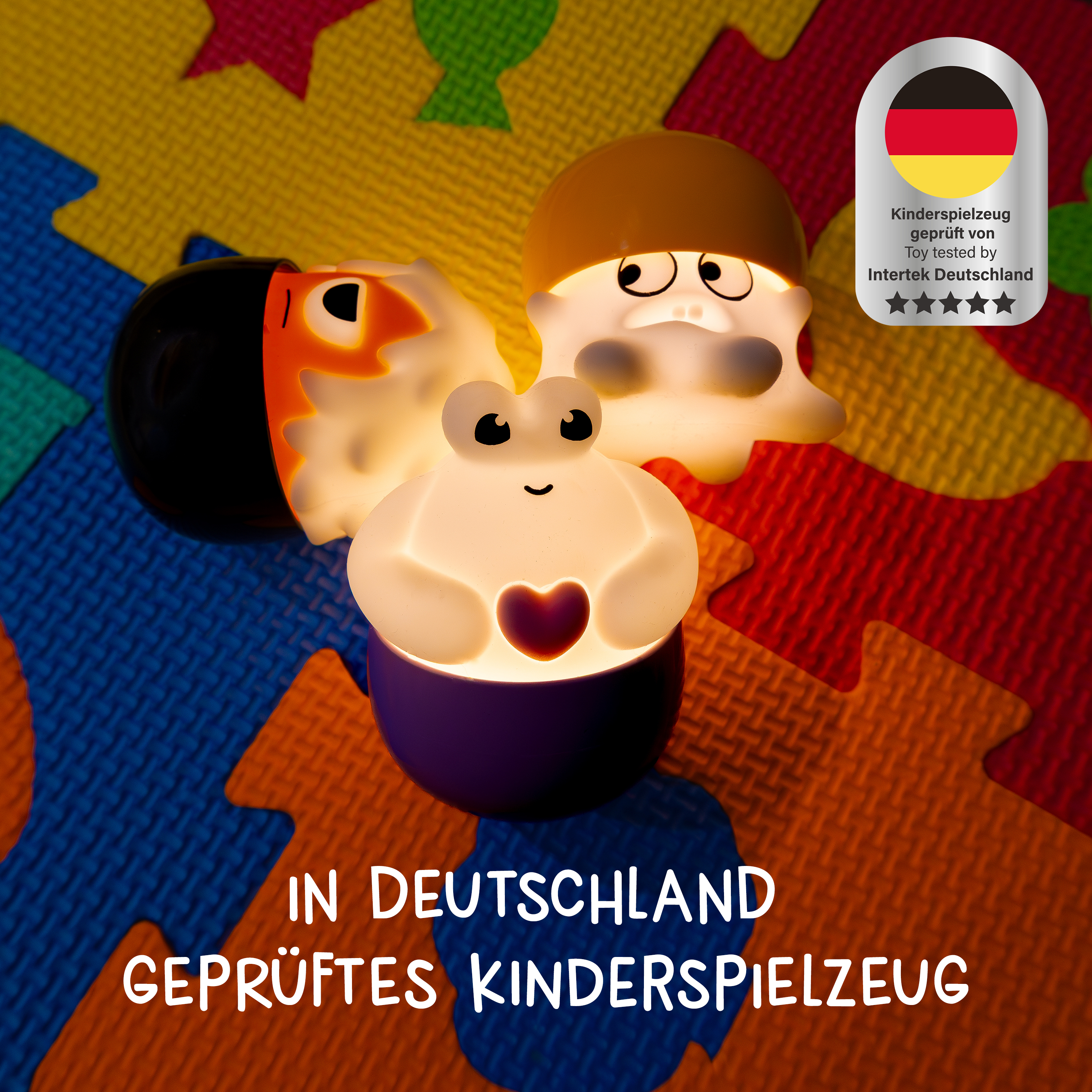 Drei beleuchtete Figuren auf einer bunten Schaumstoffmatte mit einem deutschen Prüfsiegel.