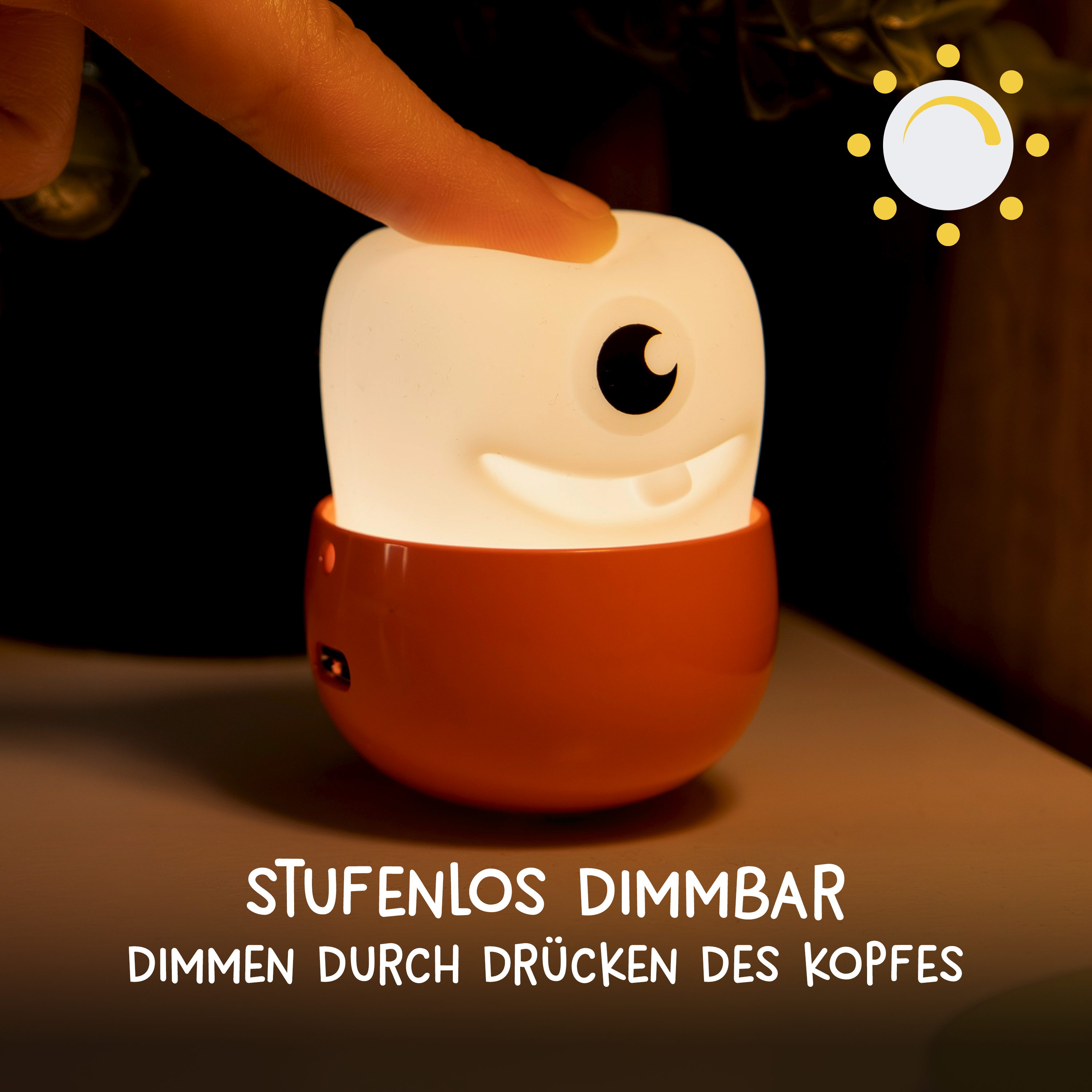 Finger drückt auf ein niedliches, einäugiges Nachtlicht mit orangem Sockel, das stufenlos dimmbar ist.