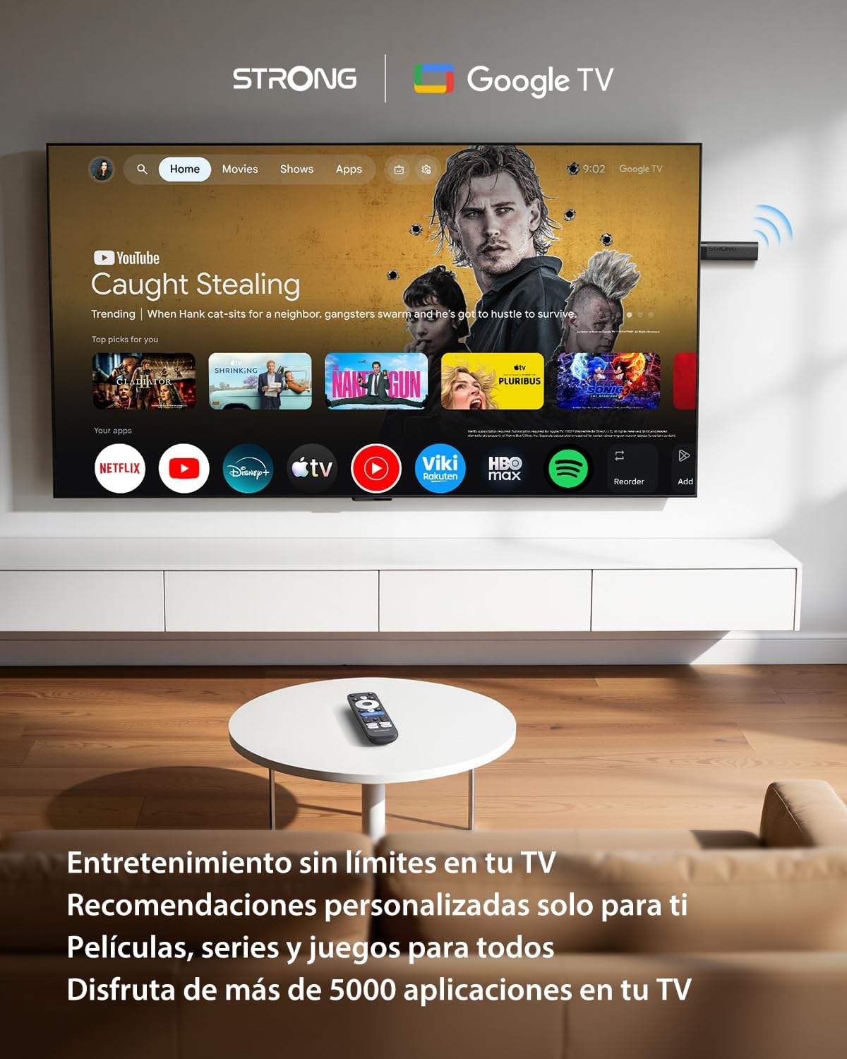 Salón con un televisor montado en la pared con Google TV, una mesa blanca redonda y un control remoto.