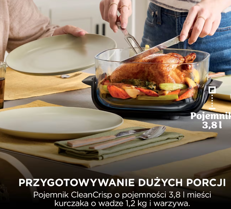 Osoba kroi pieczonego kurczaka nożem i widelcem w szklanym naczyniu na stole.