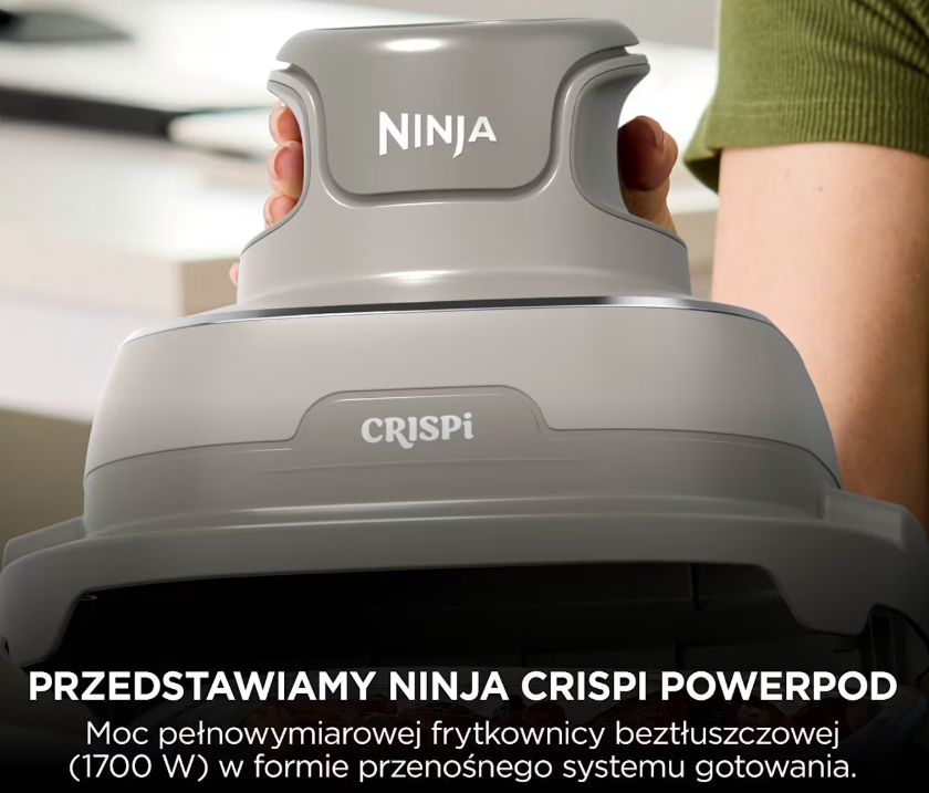 Osoba trzymająca szare urządzenie kuchenne Ninja Crispi Powerpod z polskim tekstem.