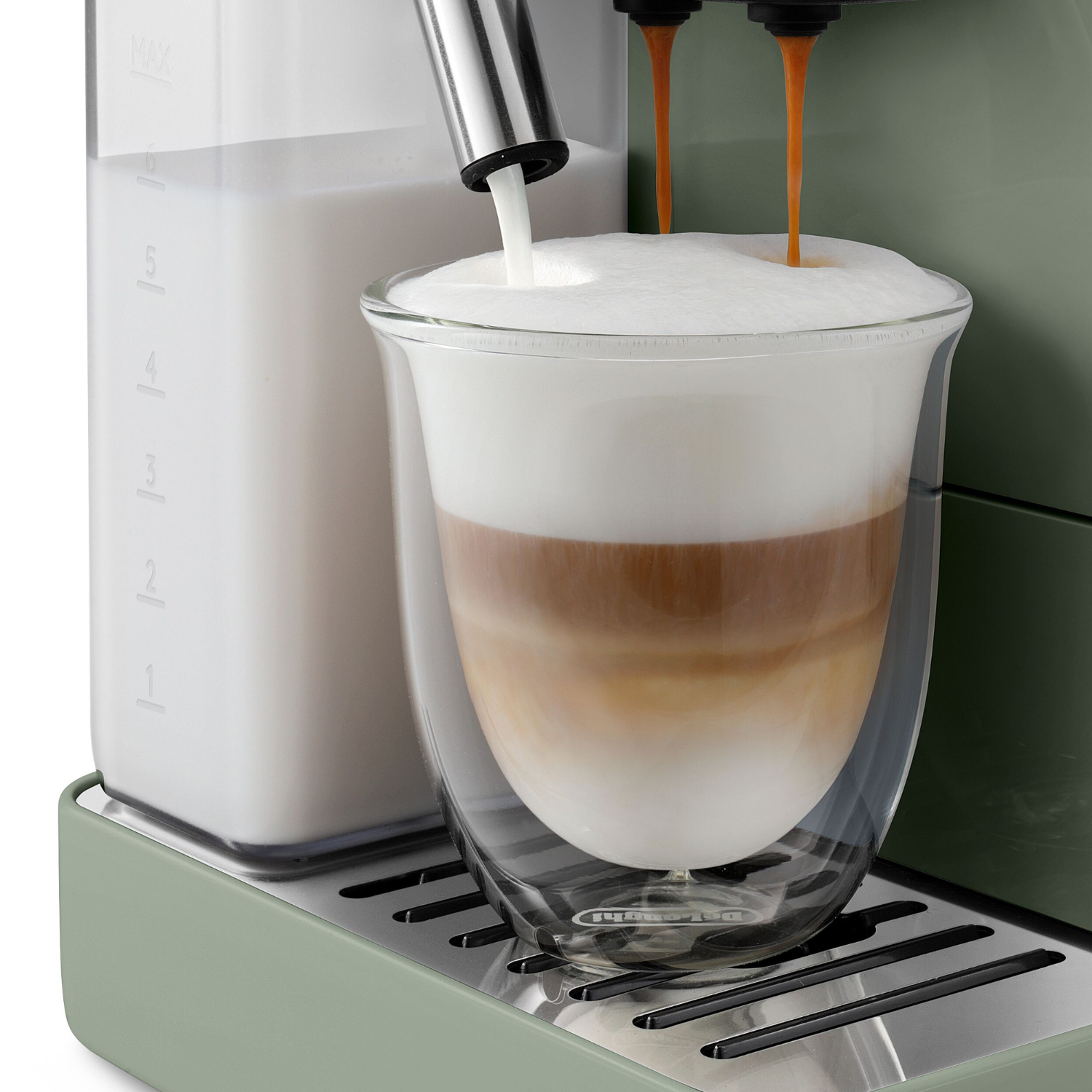 Una cafetera vierte leche y espresso en un vaso para hacer un café con leche en capas.
