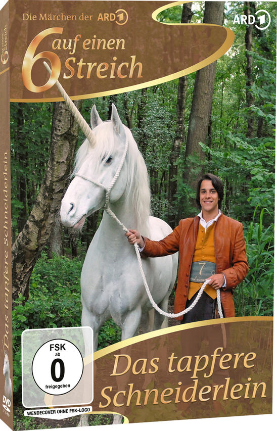 Ein Mann in brauner Jacke hält ein Seil, das an einem weißen Einhorn in einem Wald befestigt ist.