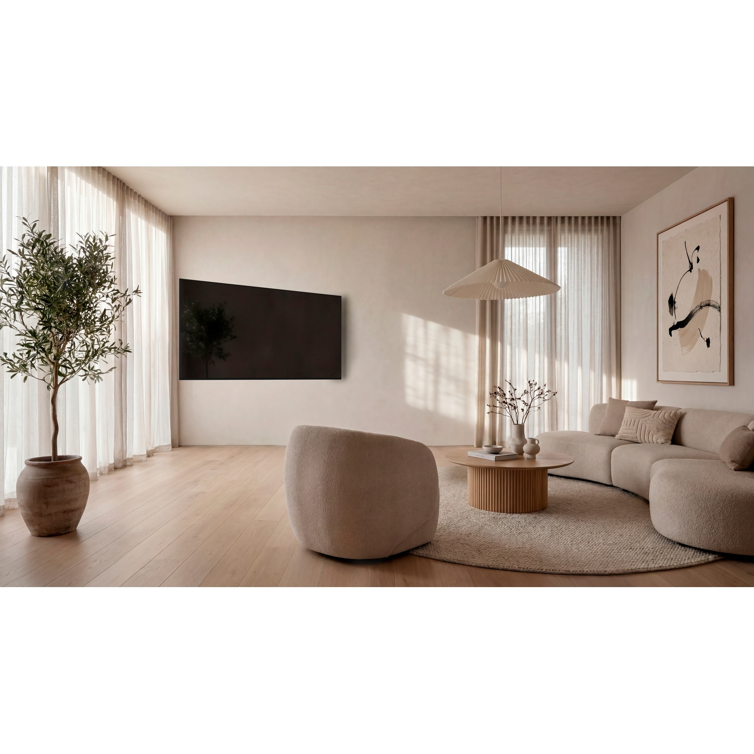 Moderne, lichte woonkamer met een gebogen bank, fauteuil, wandtelevisie en een boom in een pot.