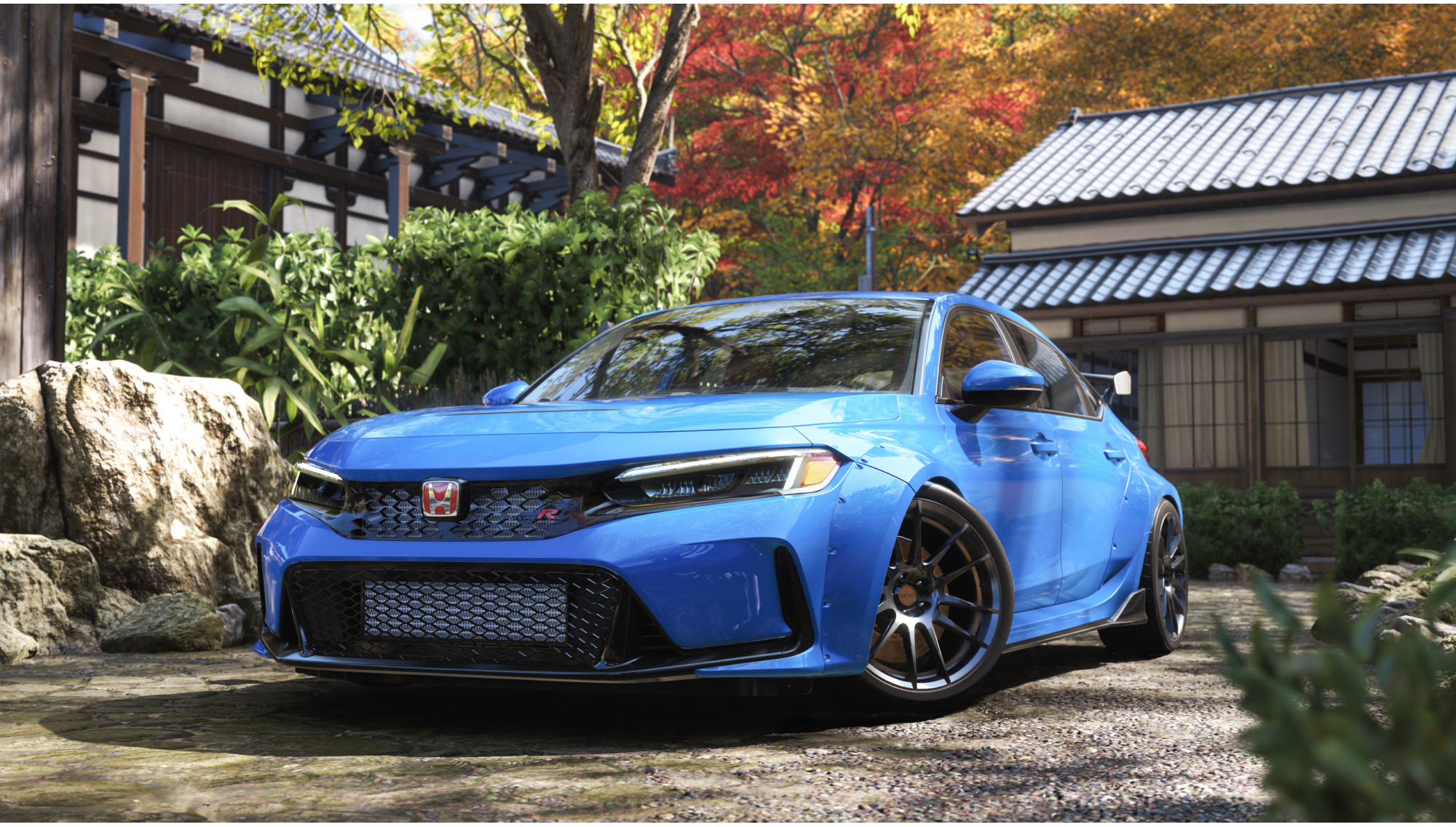 Ein blauer Honda Civic Type R parkt auf Kies vor traditionellen japanischen Gebäuden mit herbstlichen Bäumen.