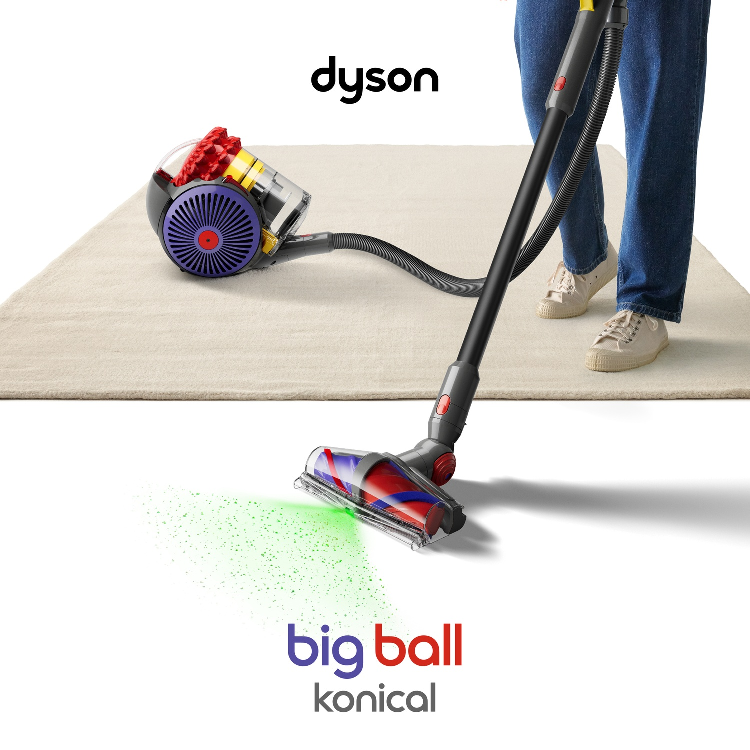 A person uses a Dyson vacuum on a rug, projecting green light onto the floor.