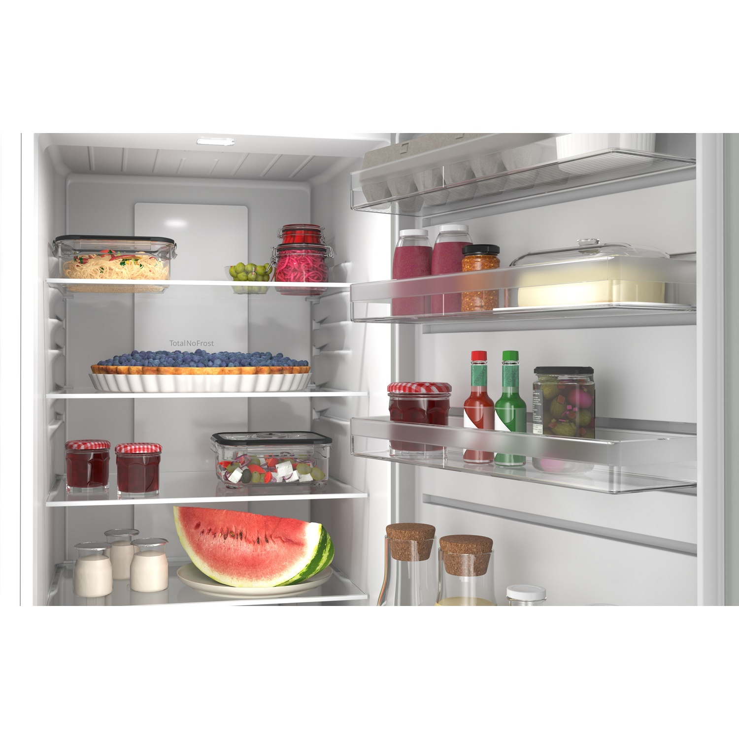 A fully stocked refrigerator with food, berry pie, watermelon, and drinks.