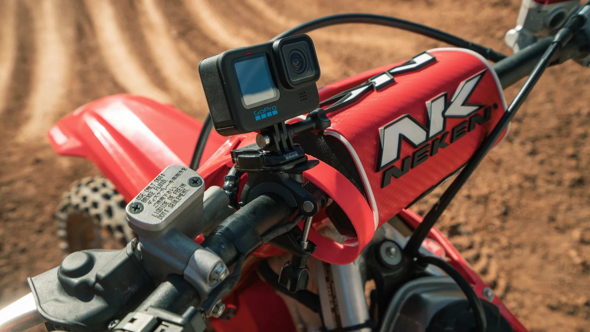 Egy GoPro kamera van felszerelve egy piros krosszmotor kormányára.