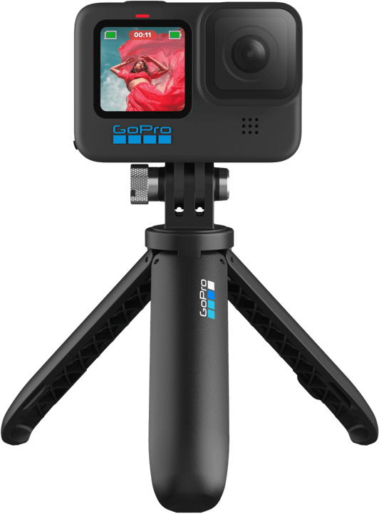 Fekete GoPro kamera kis összecsukható állványon, fekete háttér előtt.